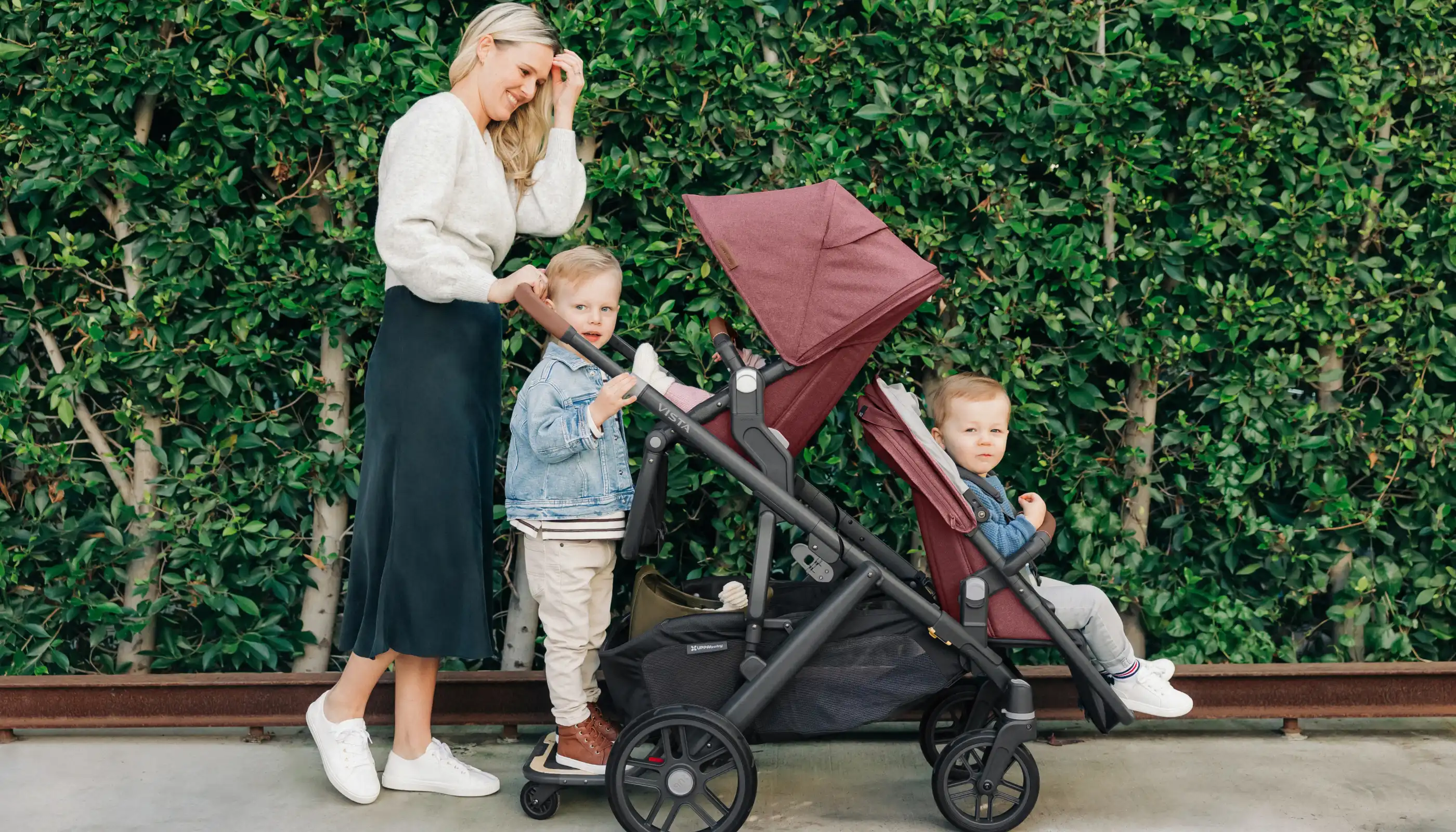 Parent pushing three children in the Vista with Toddler Seat, RumbleSeat, PiggyBack
